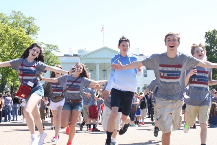 Happy smiling children running with their arms wide open. White House in the background